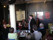 Kirjailijan sisar Hillevi Ylimartimo siirtyy esiintymislavalle muistelupuheenvuoroa varten.
